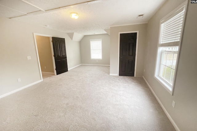 interior space with visible vents, light carpet, a textured ceiling, and baseboards