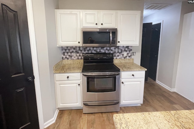 kitchen with light wood-style flooring, visible vents, baseboards, white cabinets, and appliances with stainless steel finishes