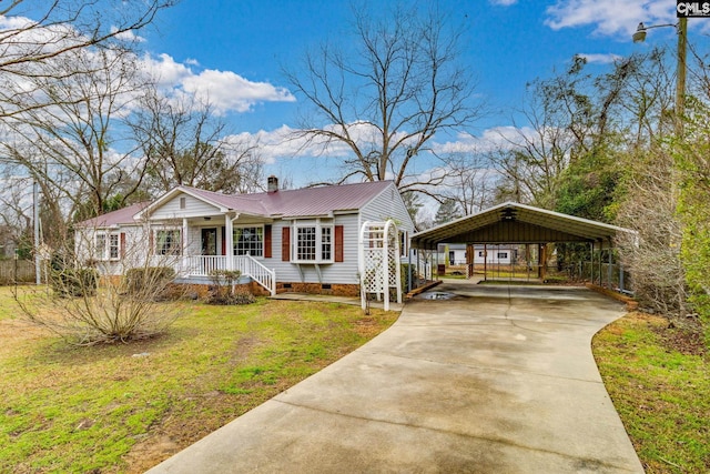 view of front facade with a detached carport, crawl space, metal roof, driveway, and a front lawn