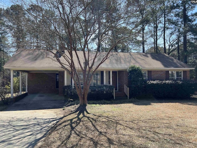 single story home featuring driveway, a carport, and brick siding