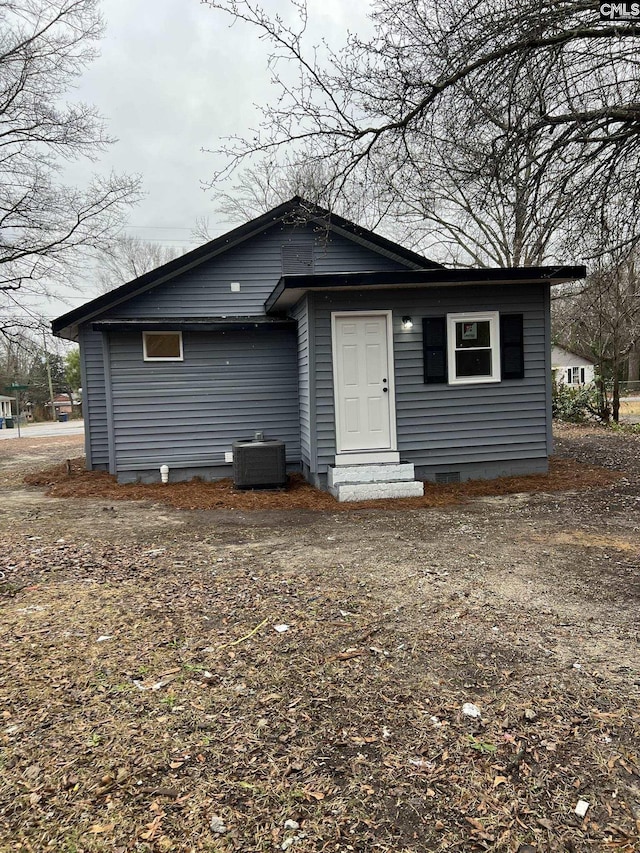 rear view of property with entry steps and central AC