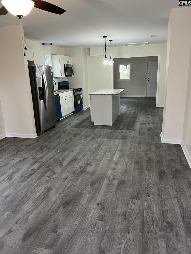 kitchen with dark wood finished floors, a kitchen island, appliances with stainless steel finishes, white cabinetry, and pendant lighting