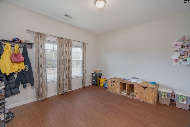 miscellaneous room featuring wood finished floors, visible vents, and baseboards