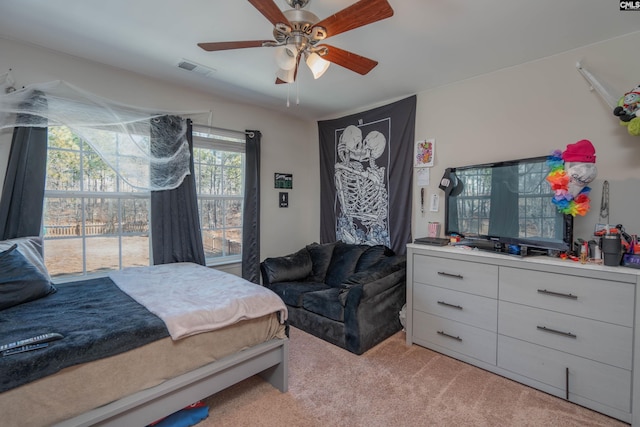 bedroom featuring ceiling fan, visible vents, and light colored carpet