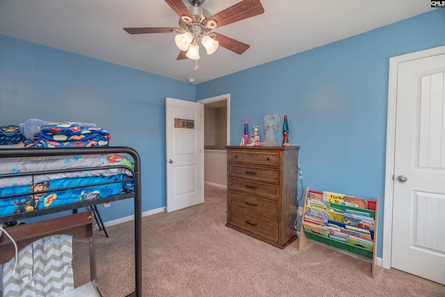 bedroom featuring light carpet, a ceiling fan, and baseboards