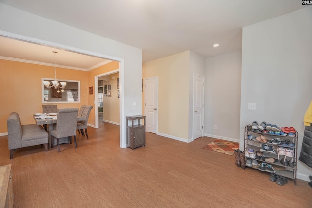 dining room featuring an inviting chandelier, crown molding, baseboards, and wood finished floors