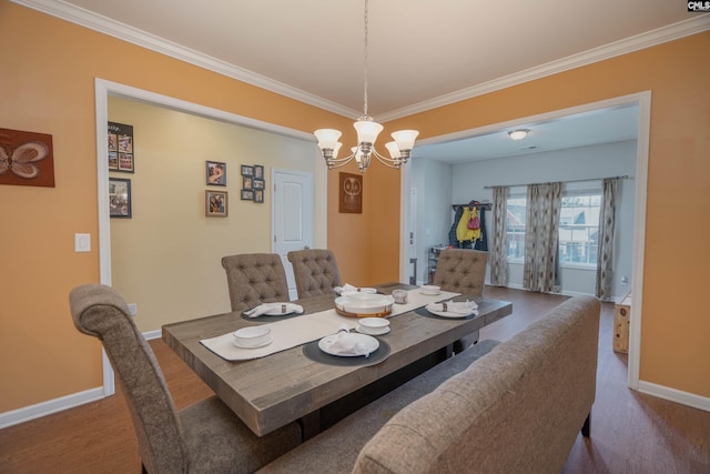 dining room featuring baseboards, wood finished floors, and crown molding