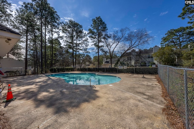 pool with a patio and fence