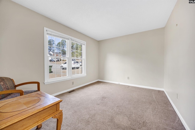 living area featuring carpet, visible vents, and baseboards