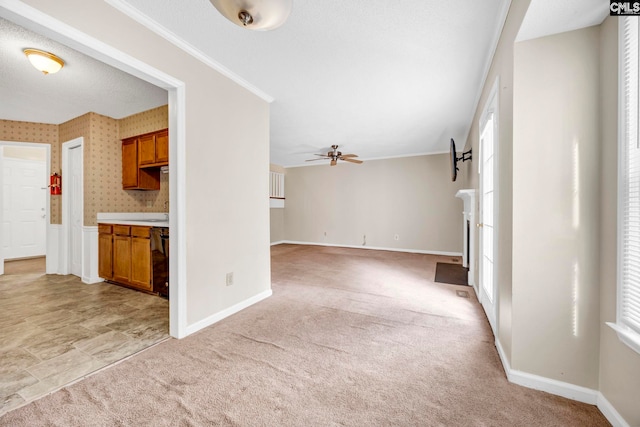 unfurnished living room featuring wallpapered walls, baseboards, and light colored carpet