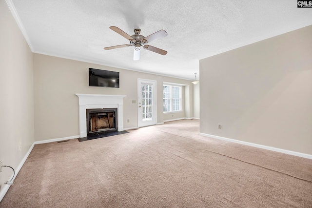 unfurnished living room with carpet flooring, a fireplace with flush hearth, baseboards, visible vents, and crown molding