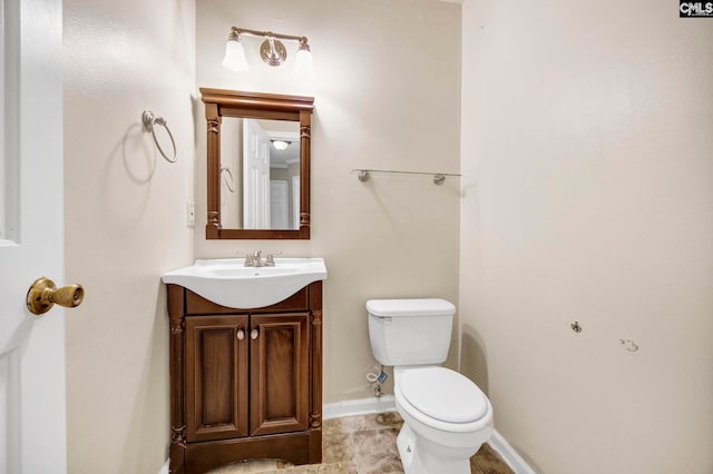 bathroom with baseboards, vanity, and toilet