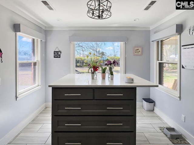 kitchen featuring a kitchen island, visible vents, and light countertops