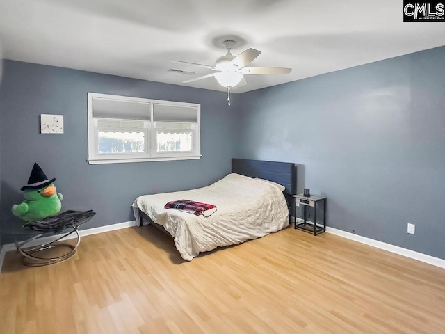 bedroom with light wood-style flooring, visible vents, ceiling fan, and baseboards