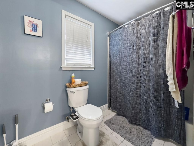 bathroom with toilet, curtained shower, baseboards, and tile patterned floors