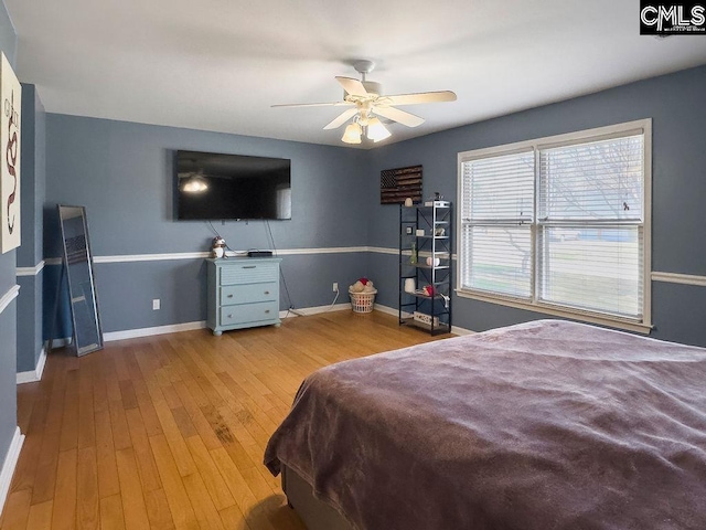 bedroom with light wood-style flooring, baseboards, and ceiling fan