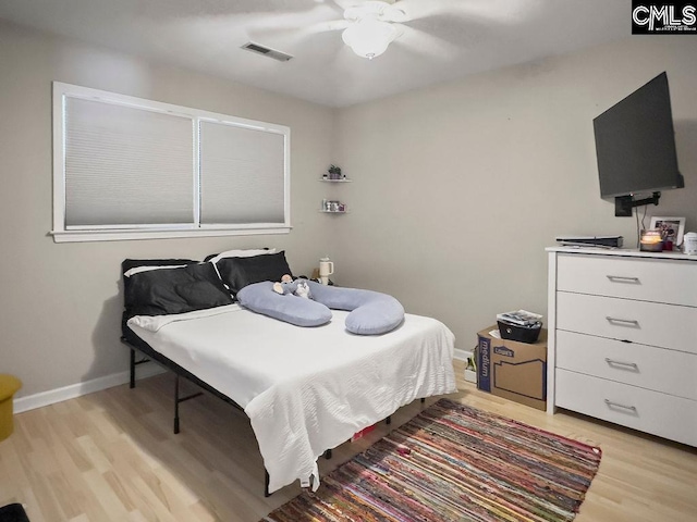 bedroom featuring a ceiling fan, baseboards, visible vents, and light wood finished floors