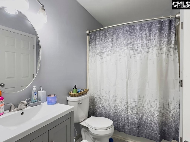 bathroom featuring toilet, a shower with shower curtain, and vanity