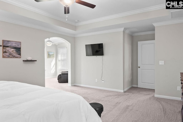 bedroom with arched walkways, a tray ceiling, crown molding, light carpet, and baseboards