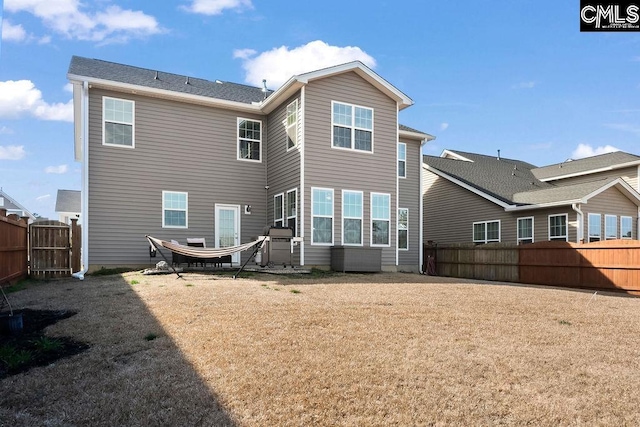 back of property with a yard and a fenced backyard