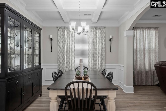 dining area featuring arched walkways, beam ceiling, a chandelier, light wood-type flooring, and coffered ceiling