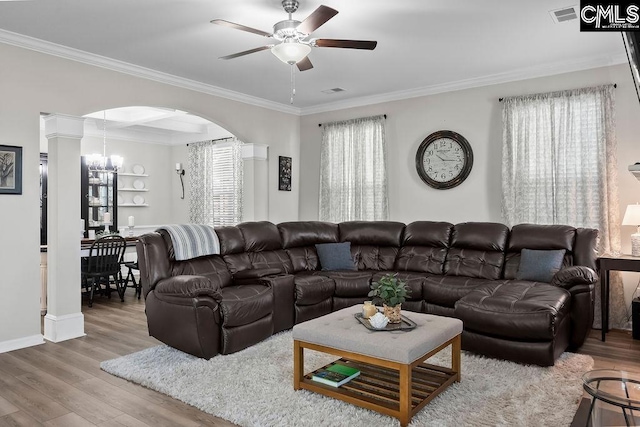 living room with arched walkways, ornamental molding, wood finished floors, and visible vents