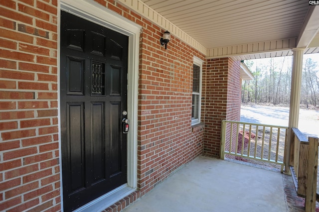 view of exterior entry with brick siding