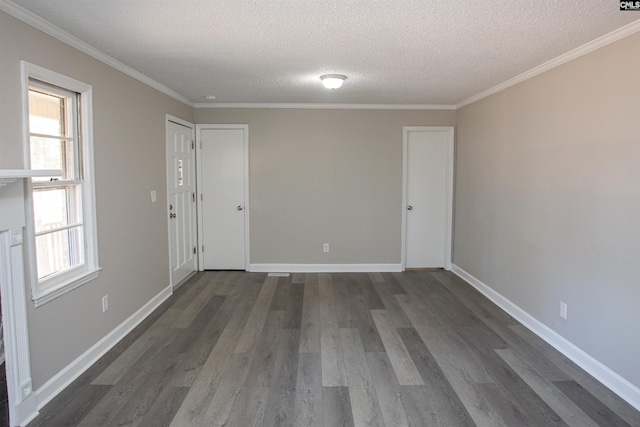 empty room with ornamental molding, dark wood-style flooring, and baseboards