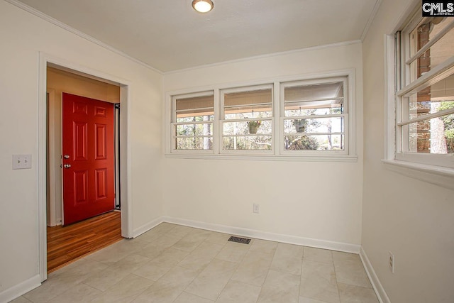 unfurnished room featuring ornamental molding and baseboards