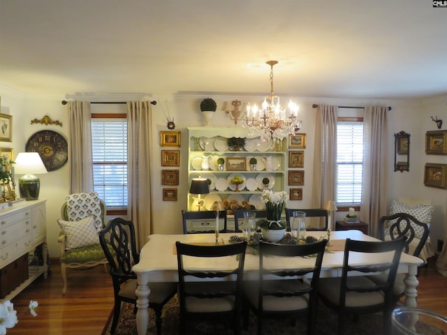 dining room featuring ornamental molding, a chandelier, and dark wood finished floors