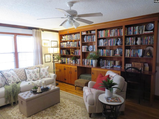 sitting room featuring a ceiling fan, a textured ceiling, and wood finished floors