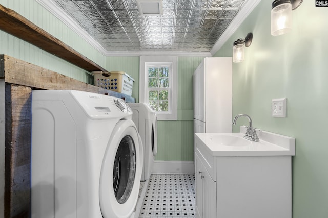 washroom with laundry area, an ornate ceiling, ornamental molding, washer and dryer, and a sink