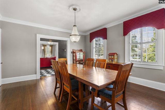 dining room featuring a chandelier, ornamental molding, dark wood-type flooring, and baseboards