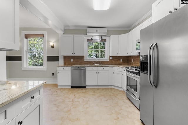 kitchen featuring stainless steel appliances, white cabinetry, a sink, and light stone counters