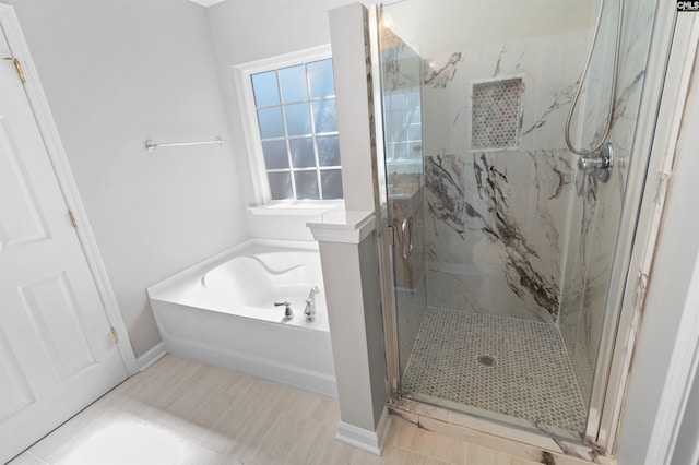 bathroom with a marble finish shower, a bath, and baseboards