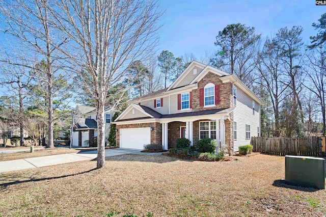 traditional home with a garage, fence, concrete driveway, and brick siding