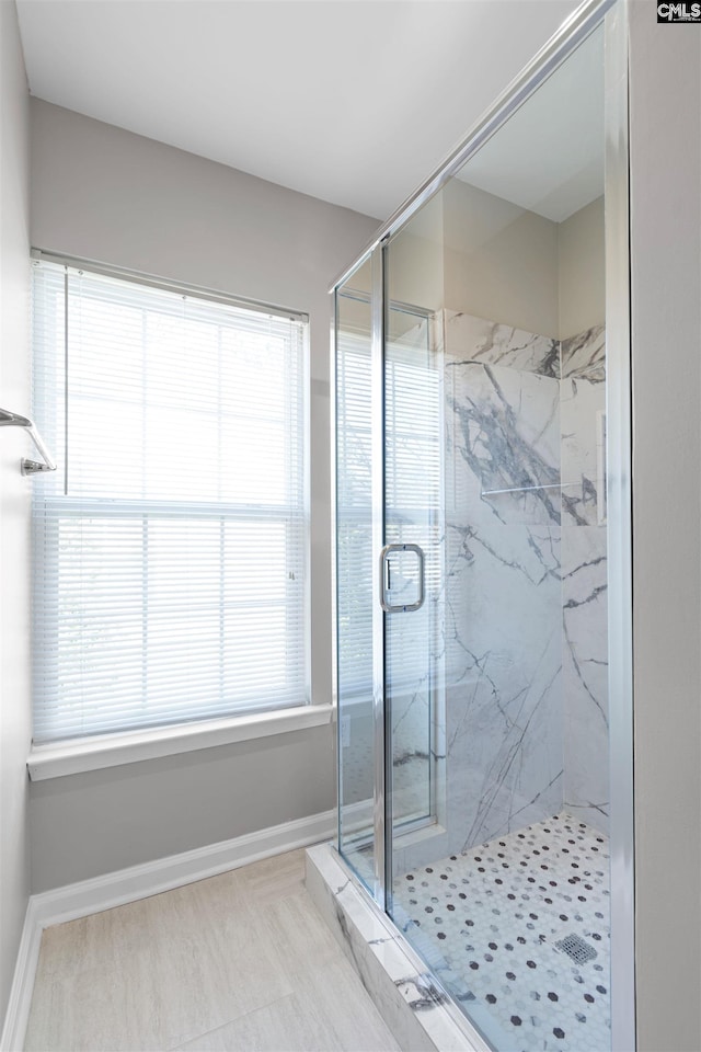 full bathroom with baseboards and a marble finish shower