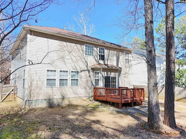 rear view of property with a wooden deck and fence