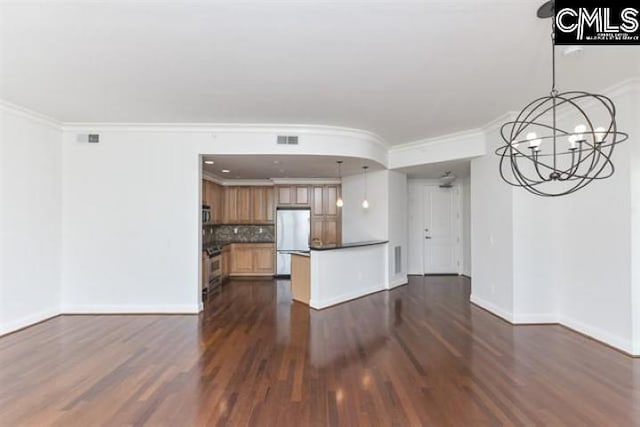 interior space featuring decorative light fixtures, dark countertops, decorative backsplash, freestanding refrigerator, and open floor plan