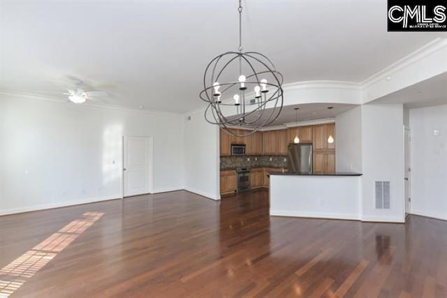 unfurnished living room with ceiling fan with notable chandelier, ornamental molding, dark wood-type flooring, and visible vents