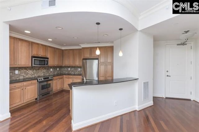 kitchen featuring appliances with stainless steel finishes, dark countertops, visible vents, and pendant lighting