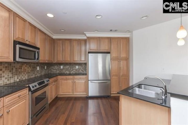 kitchen featuring stainless steel appliances, dark countertops, a sink, and pendant lighting