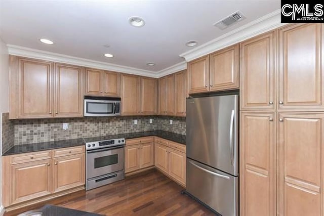 kitchen featuring stainless steel appliances, dark wood-style flooring, visible vents, tasteful backsplash, and dark countertops