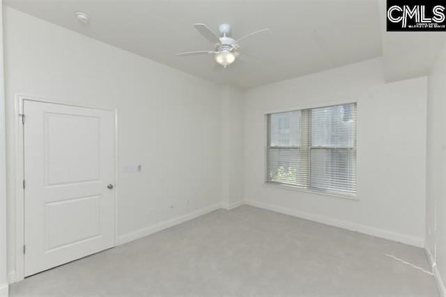 spare room featuring ceiling fan and baseboards