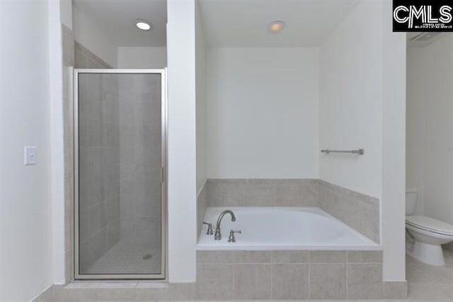 bathroom featuring a garden tub, a shower stall, and toilet