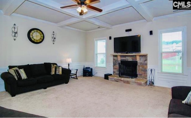 carpeted living area with a stone fireplace, wainscoting, coffered ceiling, and beam ceiling