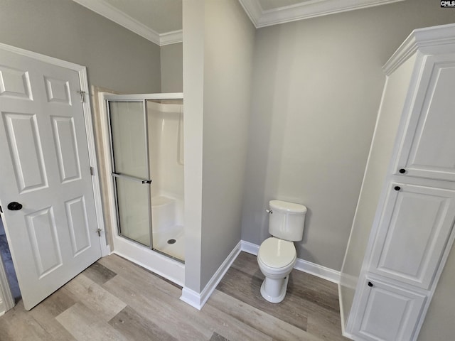 bathroom with baseboards, wood finished floors, a shower stall, and crown molding