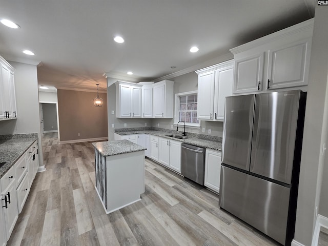 kitchen featuring stainless steel appliances, a sink, white cabinets, and a center island