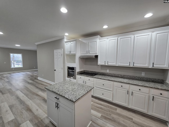 kitchen with light wood-style flooring, ornamental molding, white cabinetry, stainless steel oven, and light stone countertops