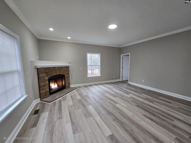 unfurnished living room with a fireplace, visible vents, light wood-style floors, ornamental molding, and baseboards